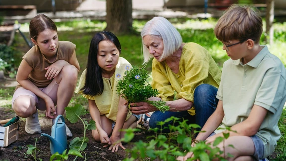 Woman teaching a group of students about gardening